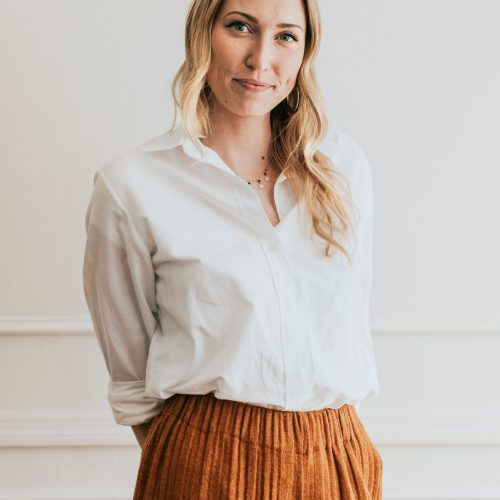 Fashionable woman standing by a white wall