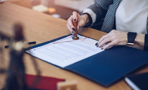 A woman notary, a lawyer stamps the seal on the documents.